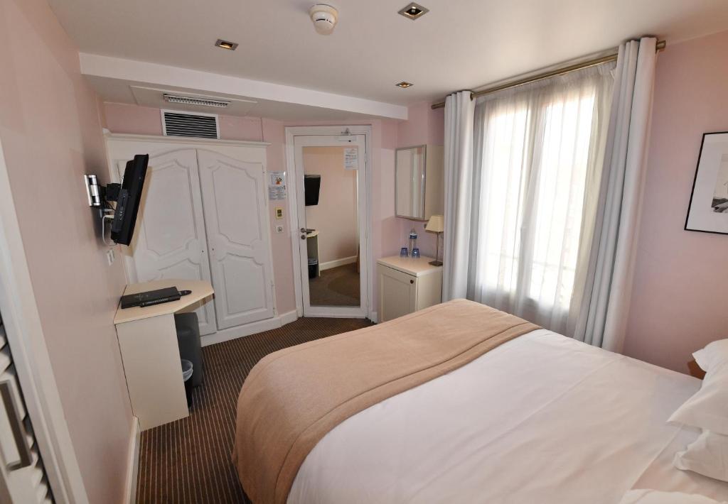 a hotel room with a bed and a window at Hôtel de Provence in Cannes
