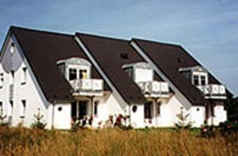 ein großes weißes Haus mit schwarzem Dach in der Unterkunft Darsser Weg 34 in Zingst