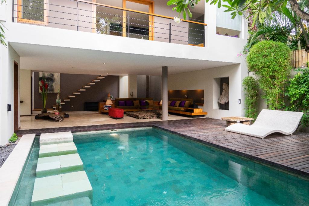a villa with a swimming pool and a house at Villa Athena in Seminyak