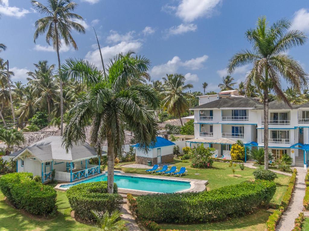 an aerial view of a house with a swimming pool and palm trees at Costarena Beach Hotel in Las Terrenas