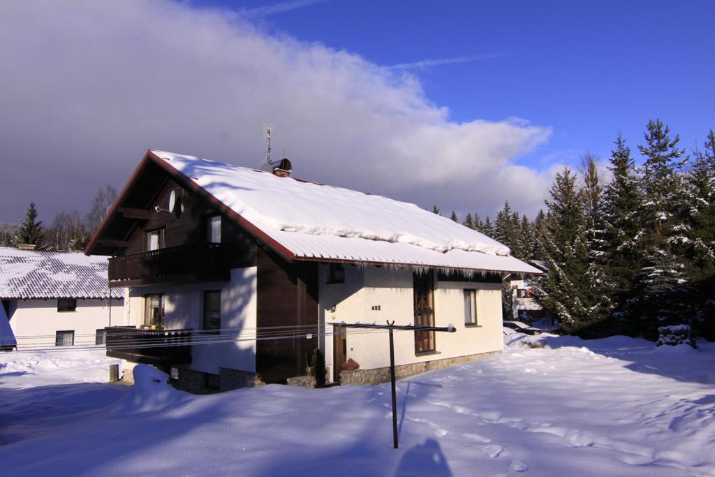 a house with snow on top of it at Pension Jana Harrachov in Harrachov