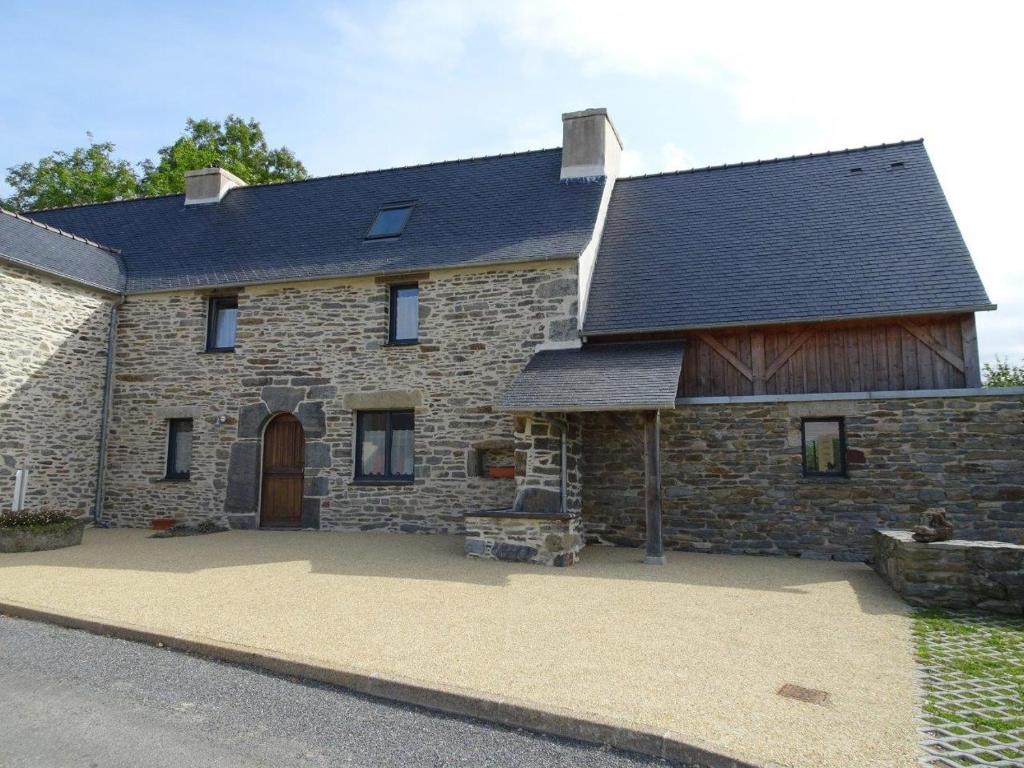 une grande maison en pierre avec une grande allée. dans l'établissement Ty-Kanndi, à Locmélar