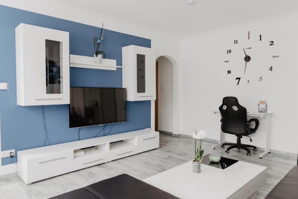 uma sala de estar com televisão numa parede azul em SK Apartments - Blue em Gelsenkirchen