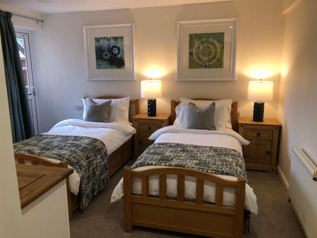 duas camas num pequeno quarto com duas lâmpadas em South Avenue B&B em Oxford