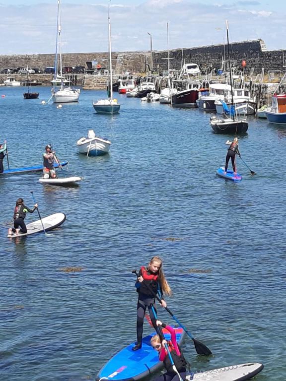 un grupo de personas en tablas de surf de remo en el agua en The Beach Hotel en Mullaghmore