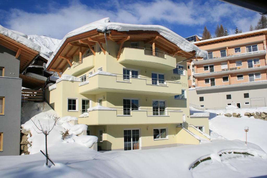 a building with snow on the ground at Apart La Vita in Sankt Anton am Arlberg