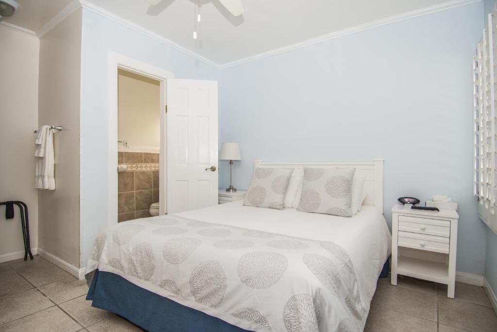 a white bedroom with a white bed and a nightstand at Venice on the Beach Hotel in Los Angeles