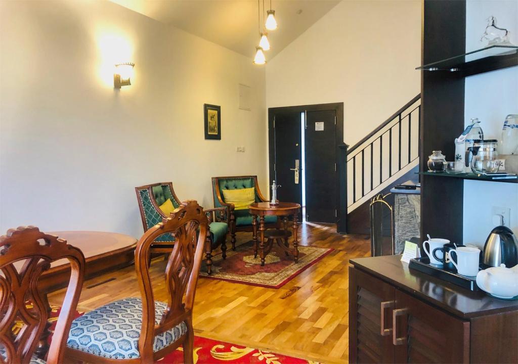 a living room with a table and a dining room at The Blackpool Resort & Spa in Nuwara Eliya