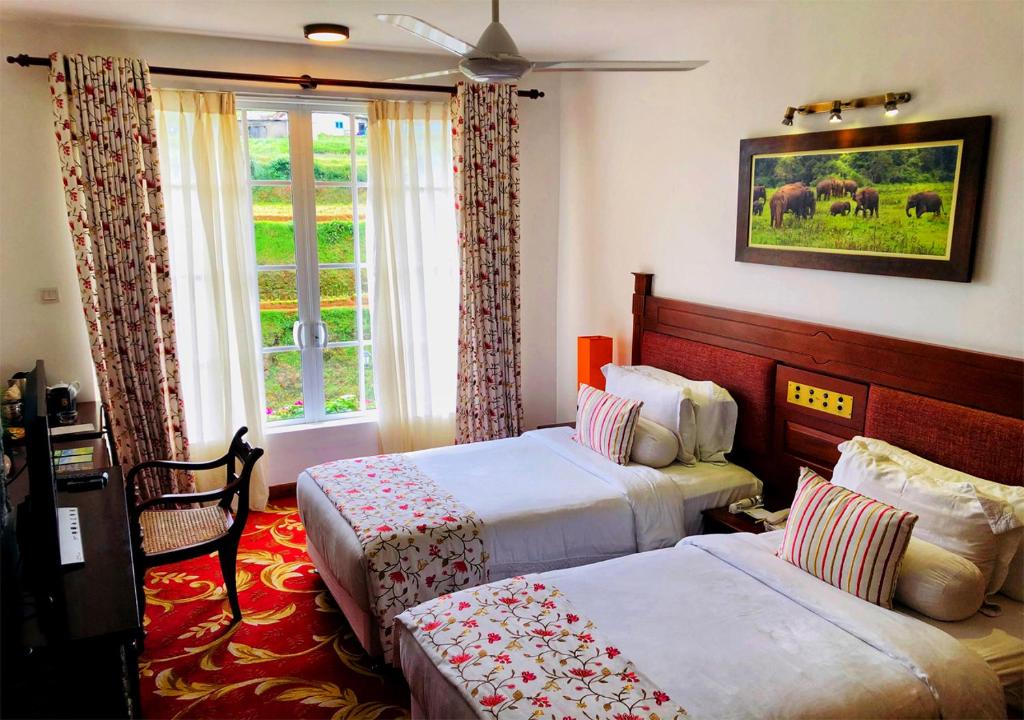 a hotel room with two beds and a window at The Blackpool Resort & Spa in Nuwara Eliya