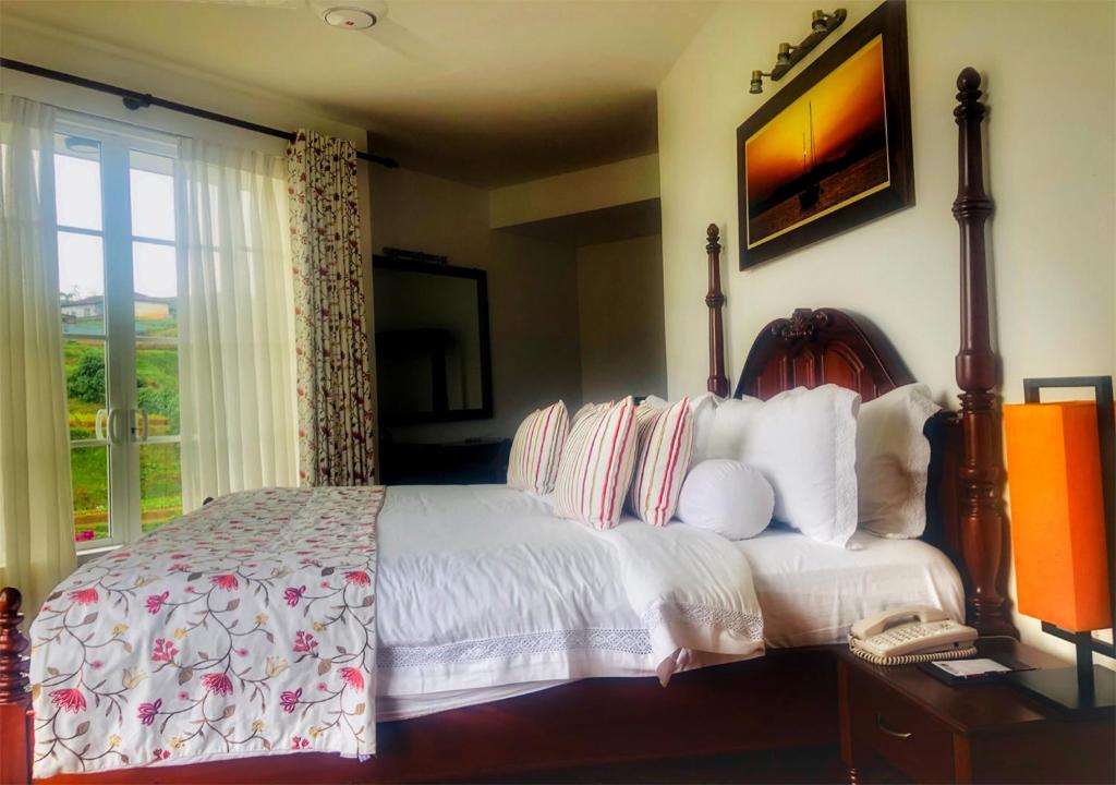 a bedroom with a large bed and a window at The Blackpool Resort & Spa in Nuwara Eliya