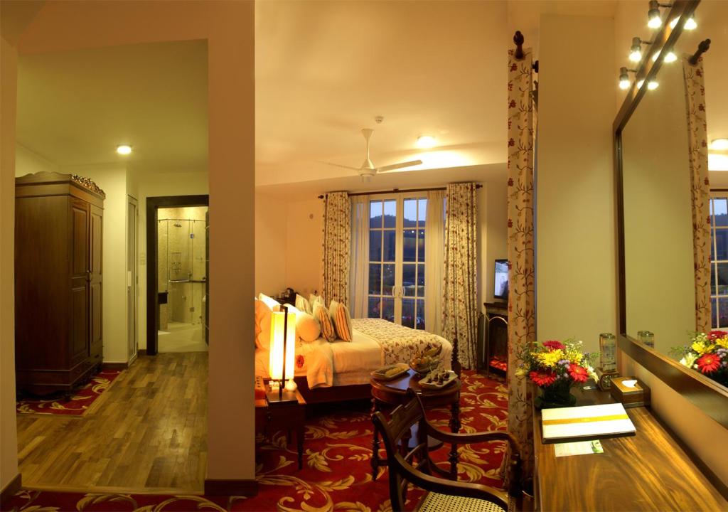 a bedroom with a bed and a living room at The Blackpool Resort & Spa in Nuwara Eliya