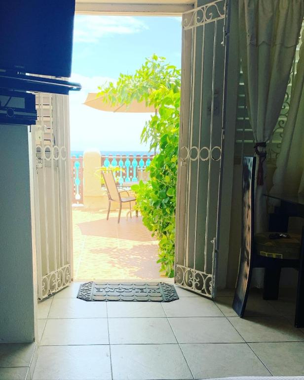 an open door to a patio with a table and chairs at Beach Vue Barbados in Bridgetown