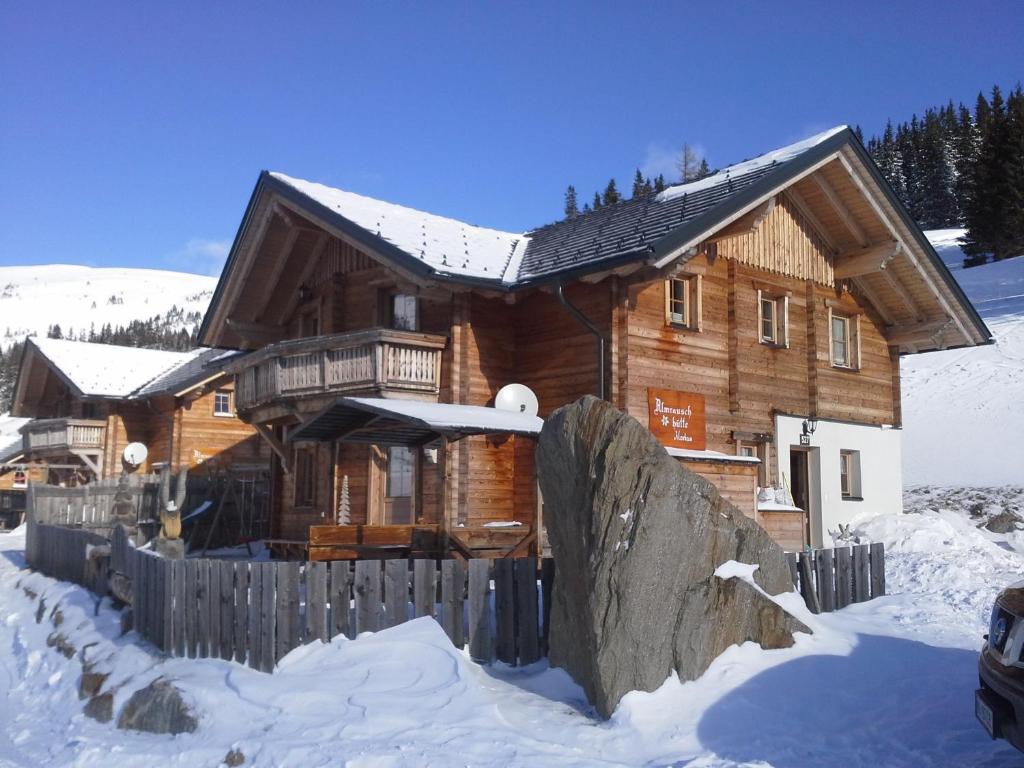 une cabane en rondins dans la neige avec une clôture dans l'établissement Almrauschhütte Markus, à Lachtal