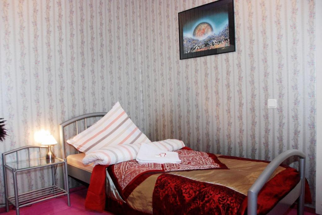 a bedroom with a bed and a picture on the wall at Guest House LT in Kaunas