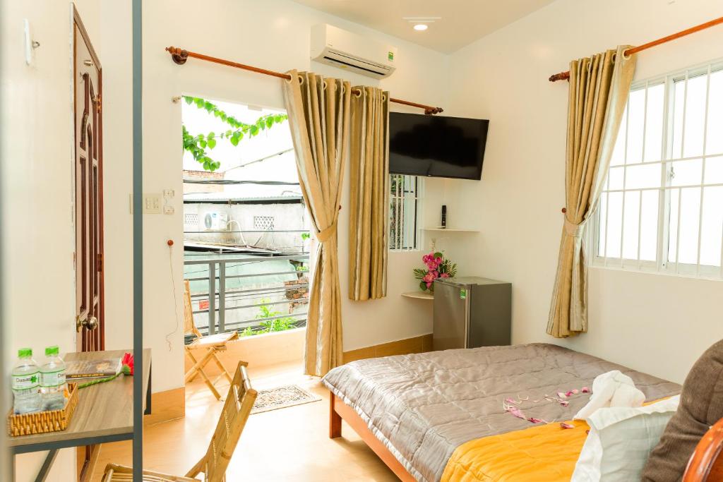 um quarto com uma cama e uma televisão na parede em Buddha Homestay em Can Tho