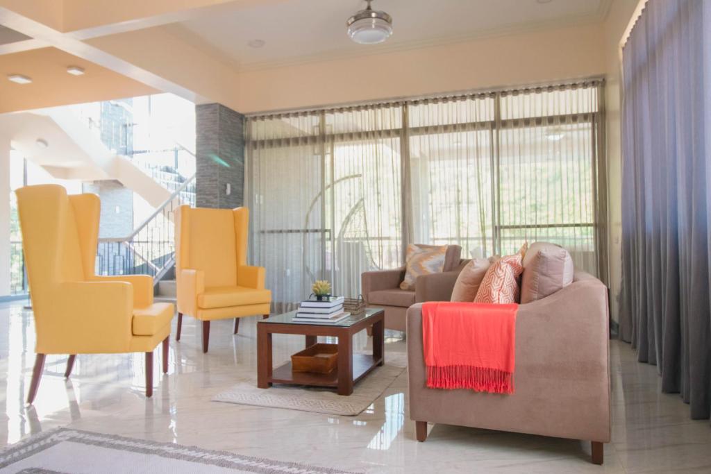 a living room with yellow chairs and a couch at Bella Villa Coron in Coron