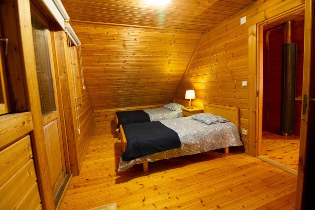 1 dormitorio con 1 cama en una cabaña de madera en Chalé 6, en Penhas da Saúde