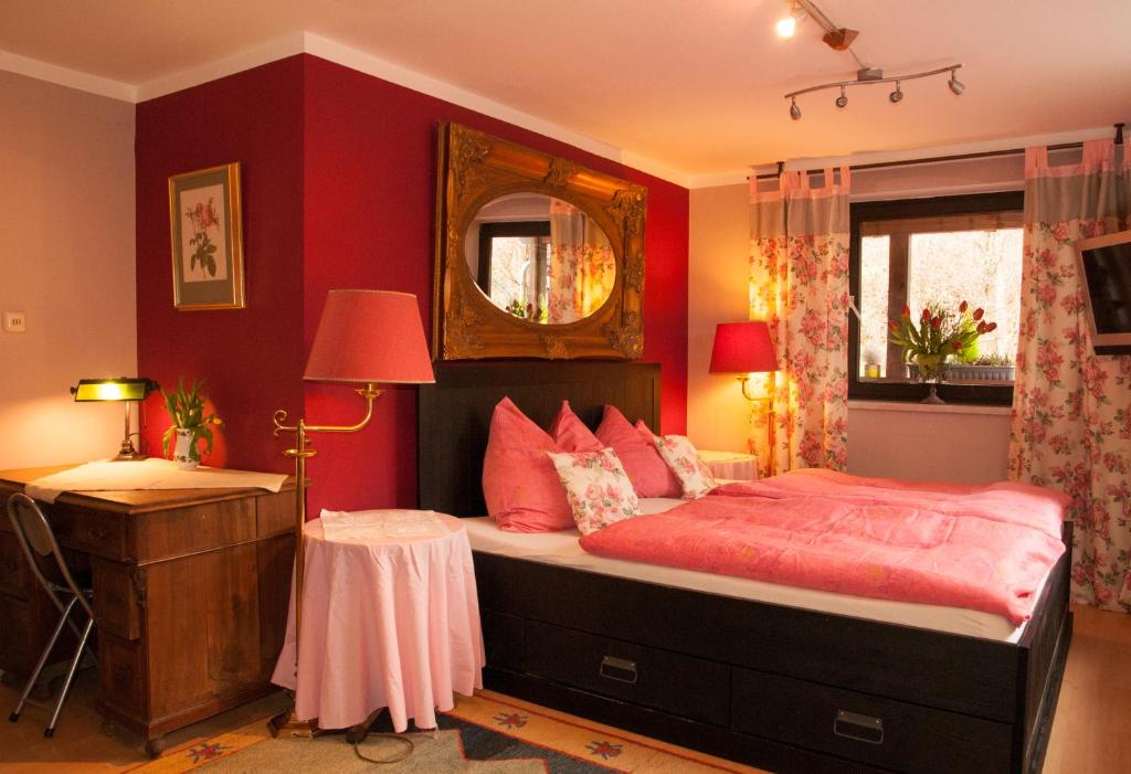 a bedroom with red walls and a bed with a mirror at Charming Apartment with Mountain View in Altmünster