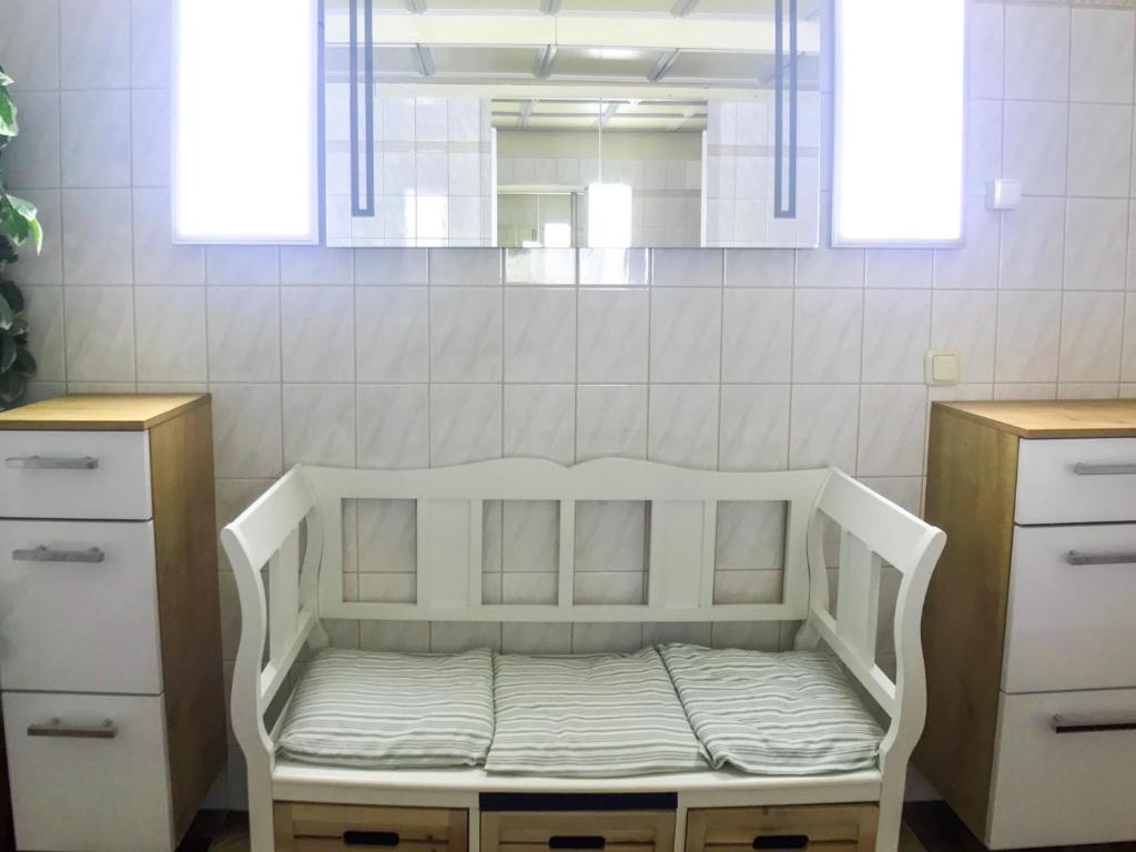 a white bed in a room with two dressers and a mirror at Charming Apartment with Mountain View in Altmünster
