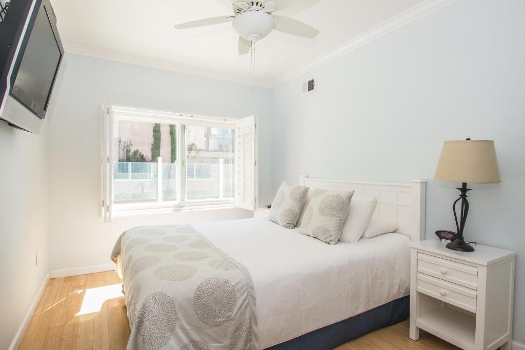 a white bedroom with a bed and a window at Venice on the Beach Hotel in Los Angeles