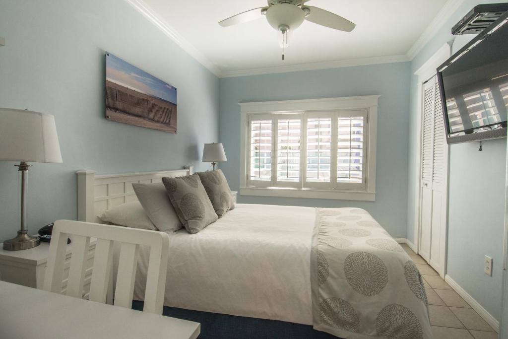 a bedroom with a white bed and a window at Venice on the Beach Hotel in Los Angeles