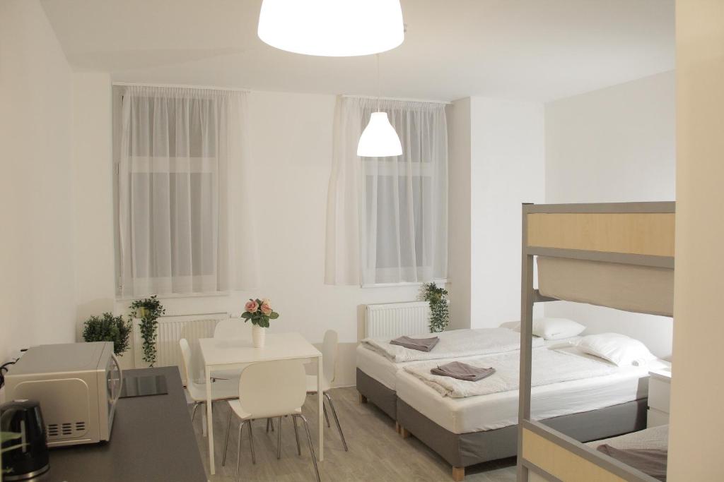 a white room with a bed and a table and a bedroom at Betariel Apartments S32 in Vienna