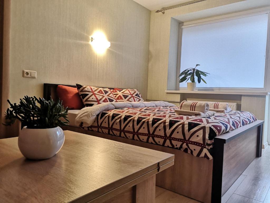 1 dormitorio con 1 cama con mesa y ventana en Raudondvario II en Kaunas