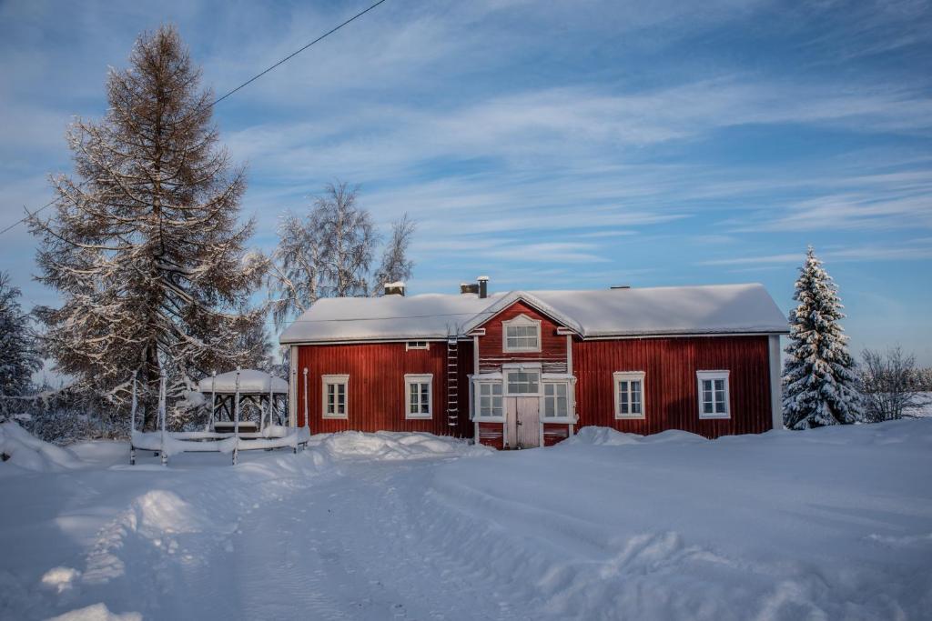a red barn with snow on top of it at Villa Seppälä in Ranua