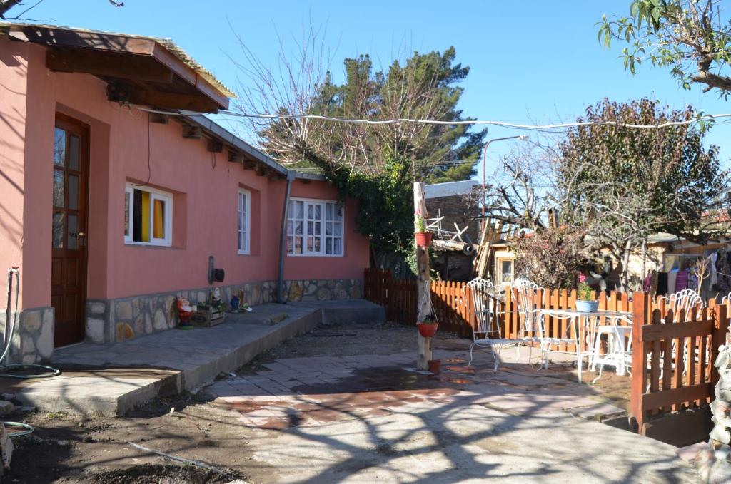 une maison rose avec une clôture devant elle dans l'établissement TAID, à Esquel