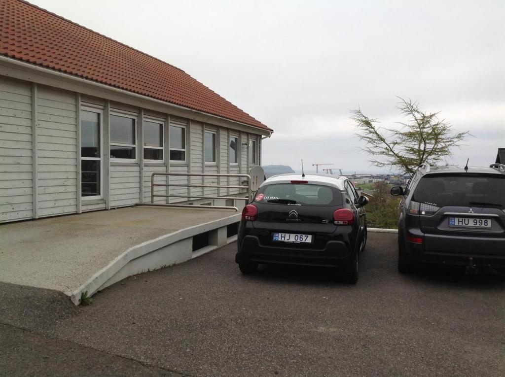 dos autos estacionados en un estacionamiento junto a una casa en Appartment Glóm C, en Tórshavn