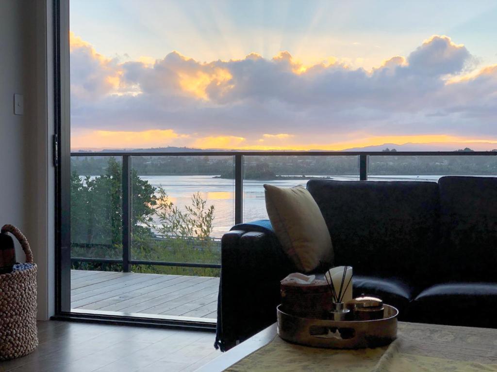 a living room with a couch and a view of the ocean at Wharf Retreat Unit 2 in Tauranga