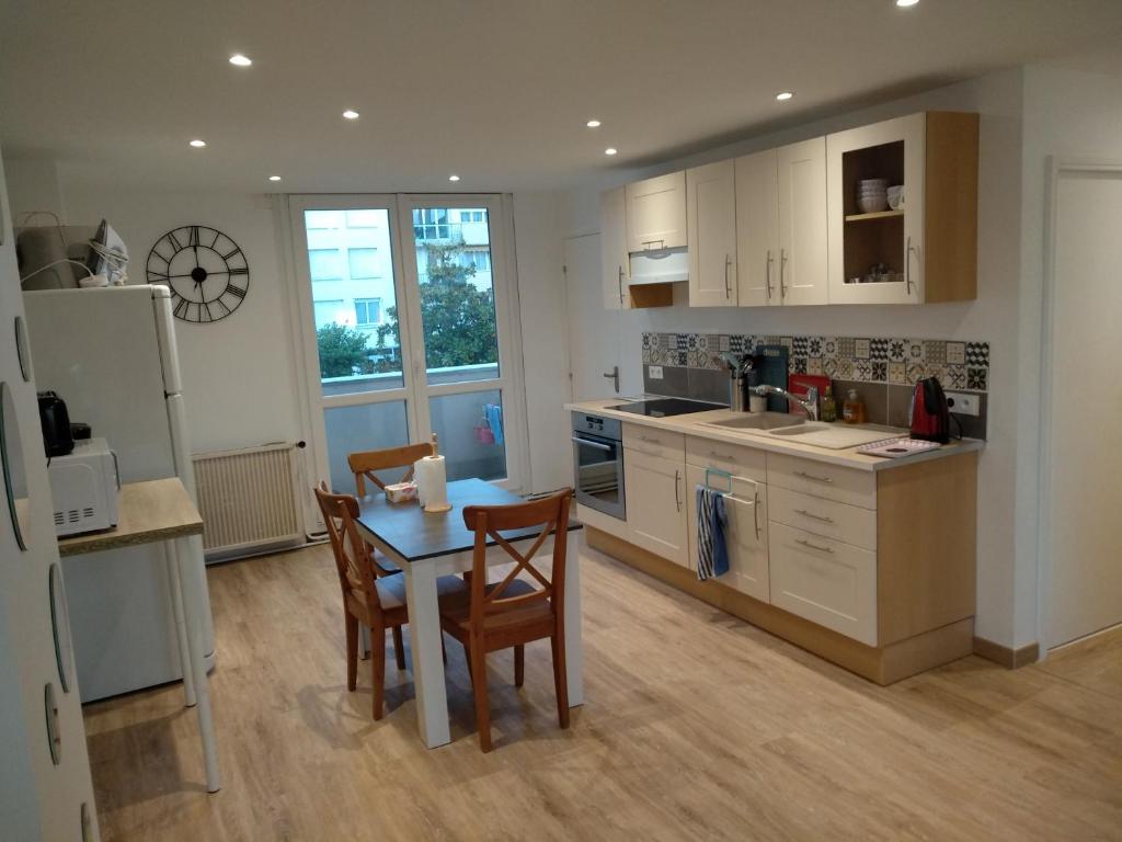 a kitchen with a table and chairs and a refrigerator at Nouveau! Appartement 80m2 tout neuf avec 3 belles chambres in Tours