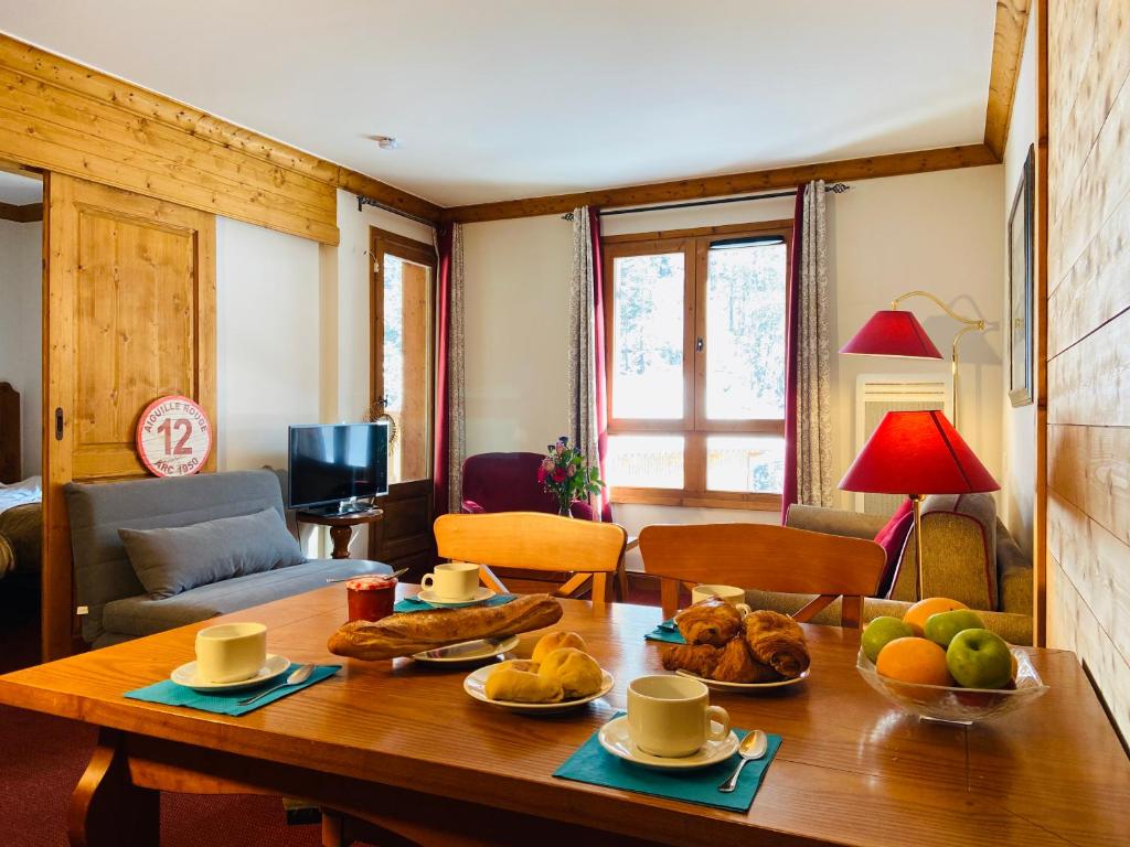 a living room with a table with food on it at ALPS les ARCS 1950 Prince des Cimes, ski-in out,swimming pool, sauna, shoes dryer in Bourg-Saint-Maurice