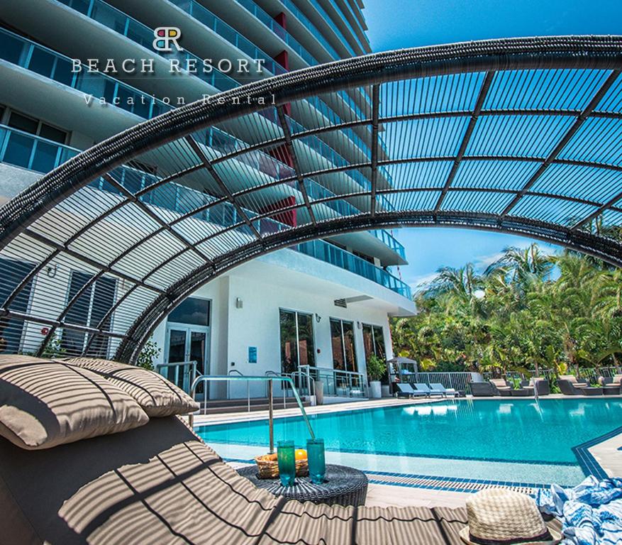 una piscina de hotel con una cama al lado de un edificio en Bwalk Resort Rentals, en Hollywood