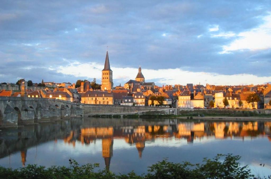 een uitzicht op een stad met een brug en een rivier bij Maison de la Loire in La Charité-sur-Loire