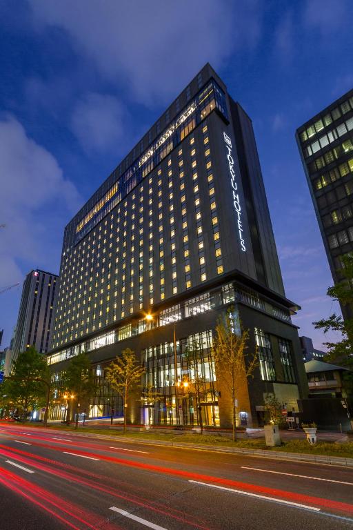 a tall building with a lot of windows on a street at Osaka Excel Hotel Tokyu in Osaka
