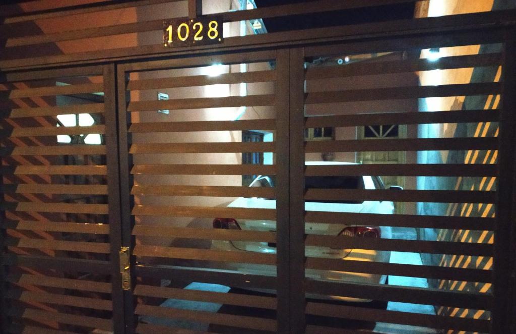 a glass door with wooden blinds on a window at Mi depa en Esquel in Esquel