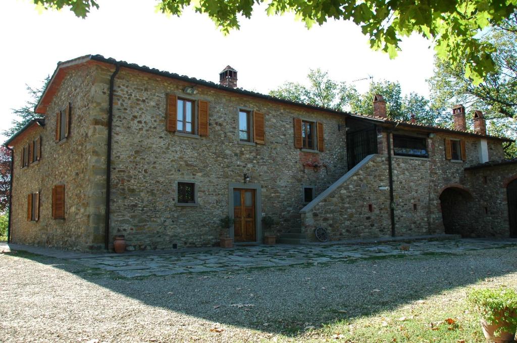 ein altes Steinhaus mit einer Treppe davor in der Unterkunft Casa Giogo in Arezzo