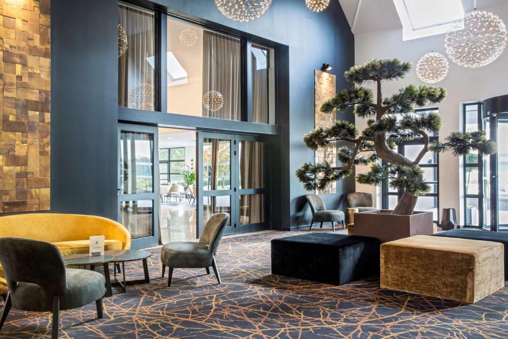 a lobby with a christmas tree and chairs at Best Western L'Aquarium Arras Nord in Fresnes-lès-Montauban