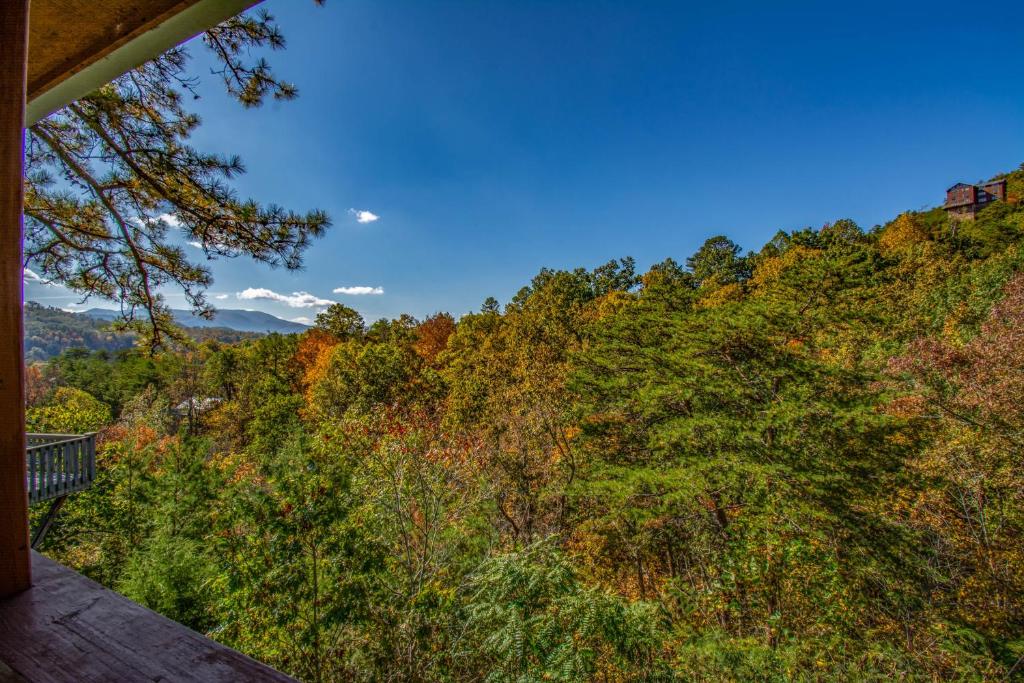 a view from the deck of a house with trees at Ladybug Resort Romantic Cabin With Mountain Views, Game Room, Close to Dollywood in Sevierville