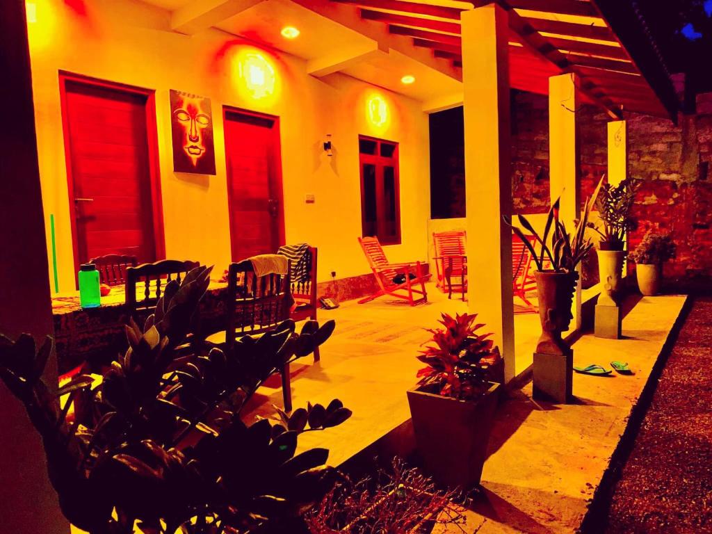 a house with red doors and a patio with plants at Villa Angel in Hikkaduwa