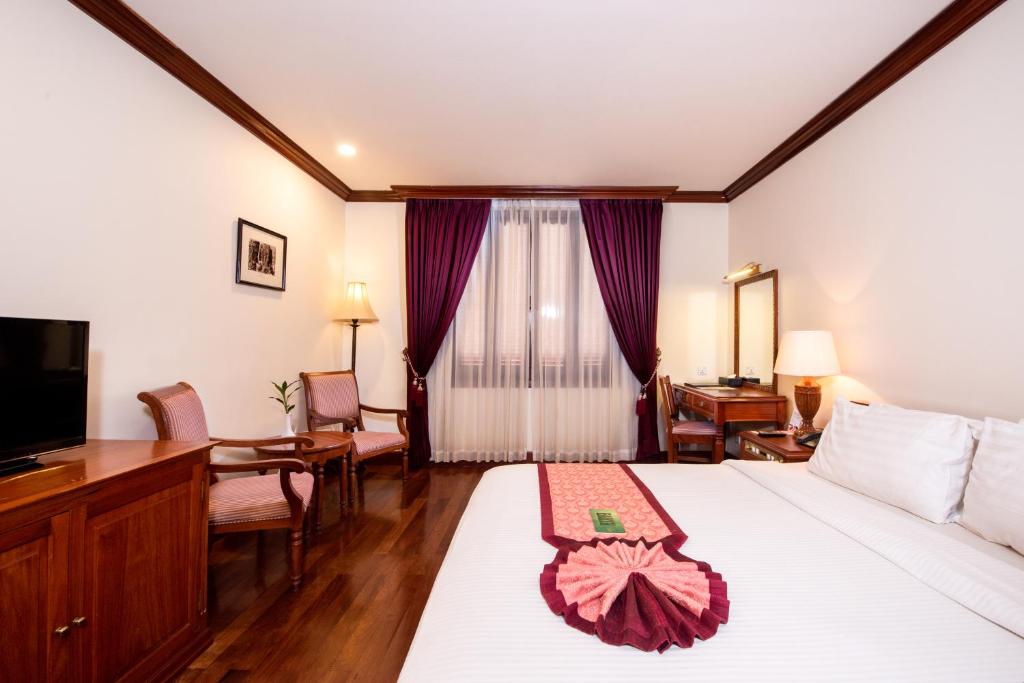 Postel nebo postele na pokoji v ubytování Steung Siemreap Hotel
