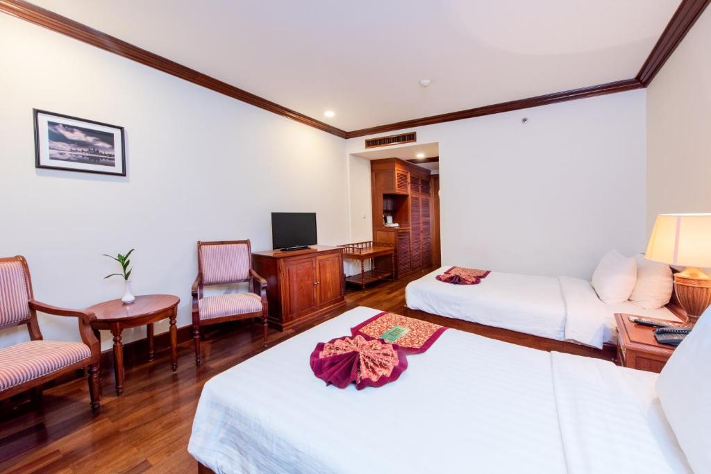 Postel nebo postele na pokoji v ubytování Steung Siemreap Hotel