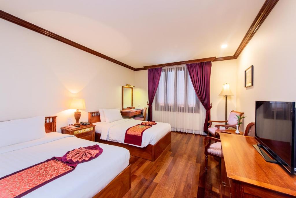Postel nebo postele na pokoji v ubytování Steung Siemreap Hotel