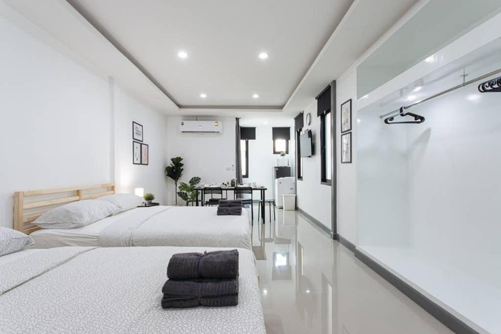 2 łóżka w pokoju z białymi ścianami w obiekcie P4 Silom Large 2beds full kitchen WIFI 4-6pax w mieście Bangkok