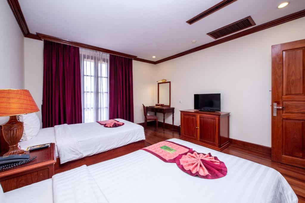 Postel nebo postele na pokoji v ubytování Steung Siemreap Hotel