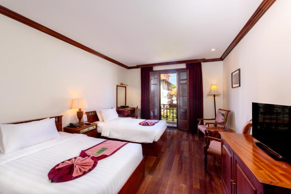 Postel nebo postele na pokoji v ubytování Steung Siemreap Hotel