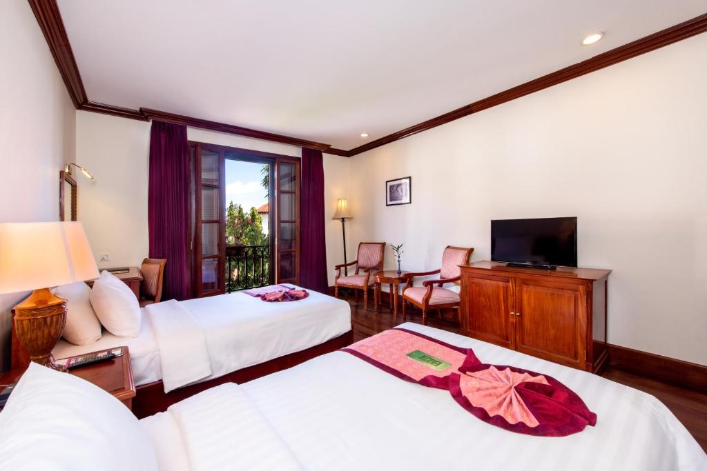 Postel nebo postele na pokoji v ubytování Steung Siemreap Hotel