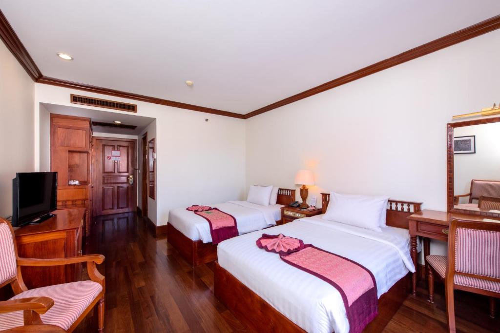 Postel nebo postele na pokoji v ubytování Steung Siemreap Hotel