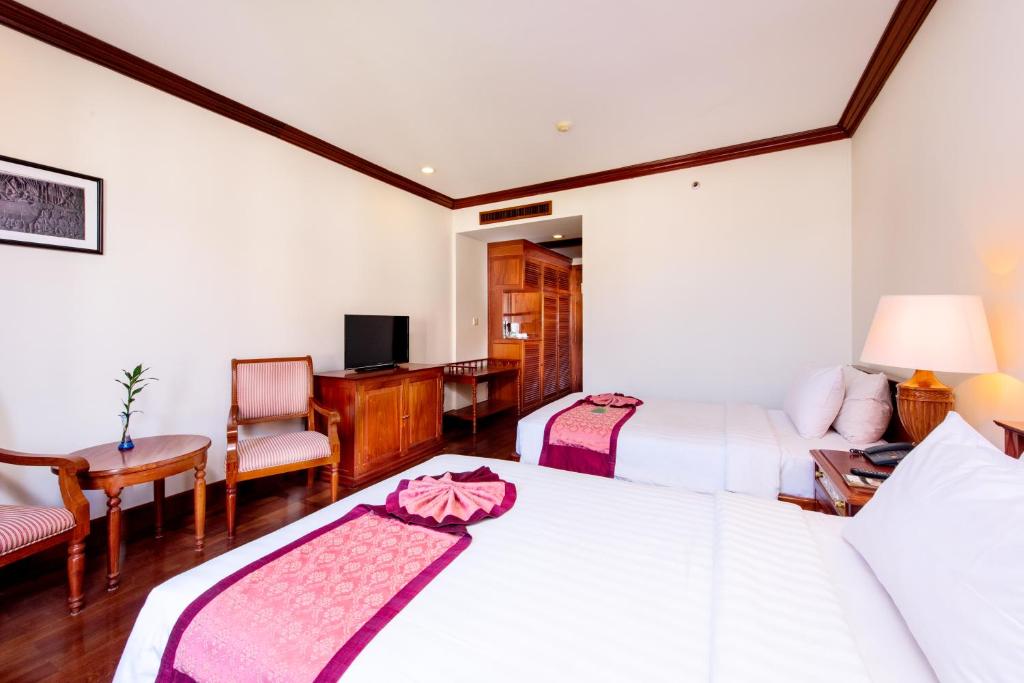 Postel nebo postele na pokoji v ubytování Steung Siemreap Hotel
